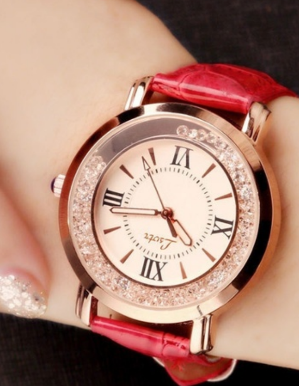 Elegant, ladies red band watch, set in gold tone, with dancing rhinestones within the watch face